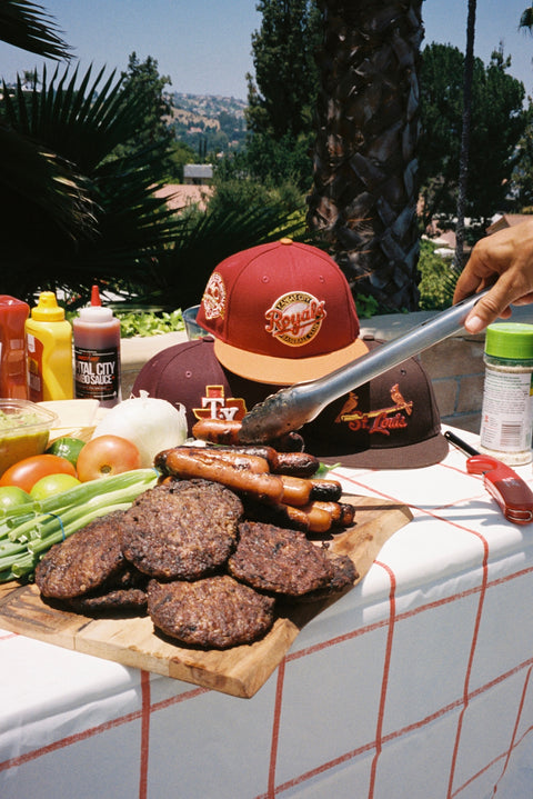 NEW ERA 5950 BBQ COLLECTION HERO IMAGE-MLB FITTED HATS ON TABLE NEXT TO BBQ FOOD-KANSAS CITY ROYALS,TEXAS RANGERS,ST.LOUIS CARDINALS
